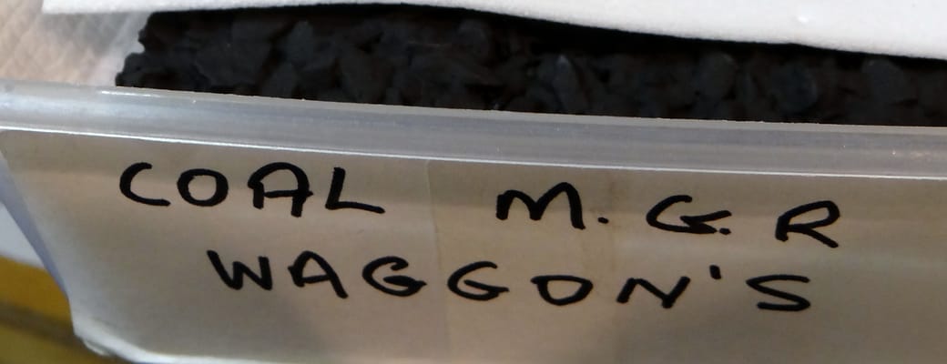 A plastic tub of coal loads, labelled in his hand: “COAL M.G.R WAGGON’S”.