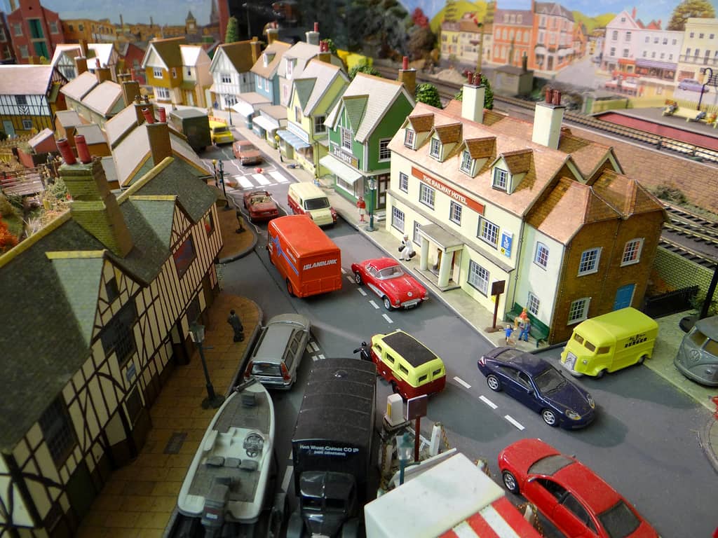 Model street seen from above, with the cream Railway Hotel on the right, shops and houses beyond, and cars, vans and a black lorry along the road.
